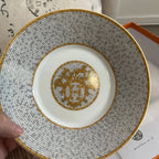 The Hermes Mosaique au 24 gold breakfast cup and saucer set of 2 features a luxurious and elegant design by the renowned brand, HERMES.