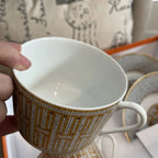 The Hermes Mosaique au 24 gold breakfast cup and saucer set of 2 features a luxurious and elegant design by the renowned brand, HERMES.