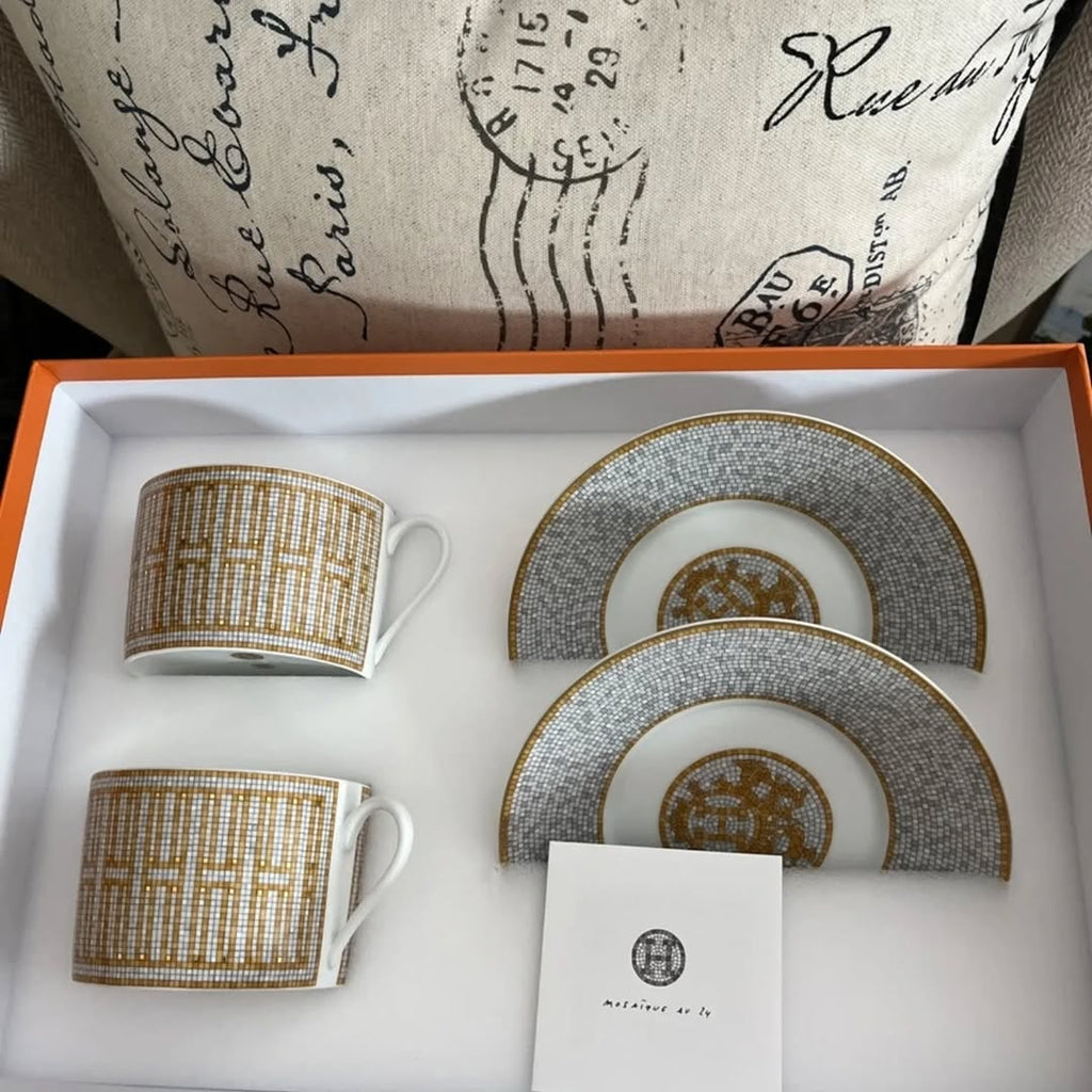 The Hermes Mosaique au 24 gold breakfast cup and saucer set of 2 features a luxurious and elegant design by the renowned brand, HERMES.